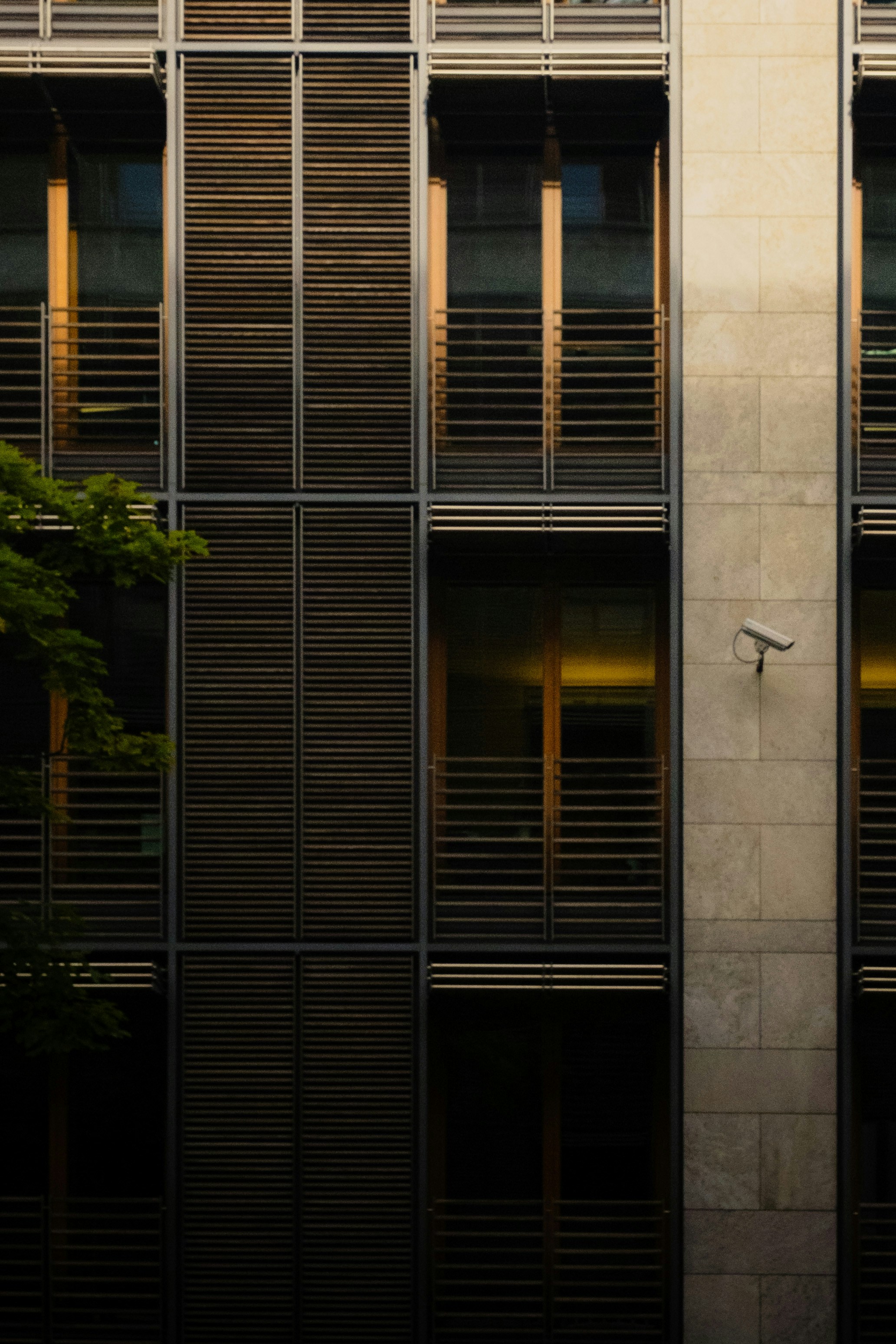 Modern stone and window facade with an attached security camera.