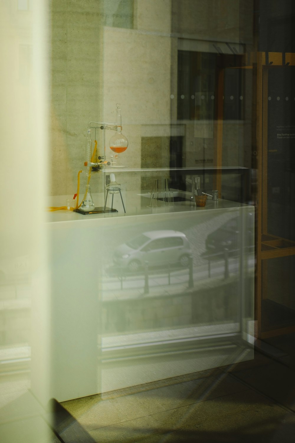 a glass door with a white car and a white car parked in it