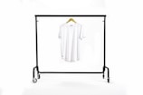 A vibrant t-shirt hanging on a wooden rack in a cozy, modern studio.