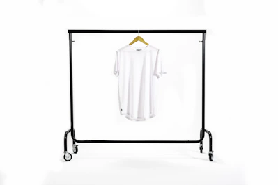 A crisp white modern shirt displayed on a minimalist hanger against a cream background
