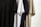 Several T-shirts hang vertically, featuring different colors including black, white, navy blue, and beige. The T-shirts are displayed side by side, showcasing their short sleeves and simple fabric texture.