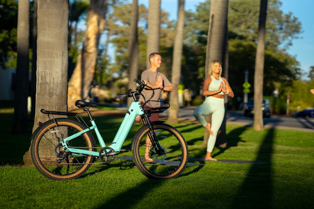 a man and woman posing next to a bicycle