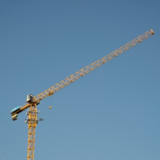 a yellow crane with a blue sky