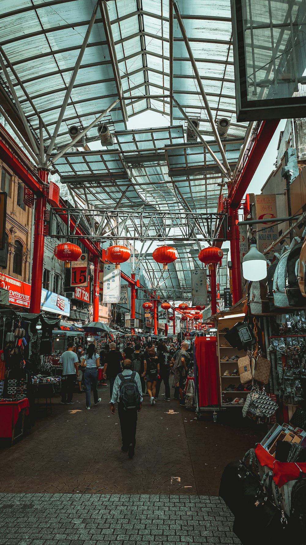 a large room with many people and lanterns from the ceiling