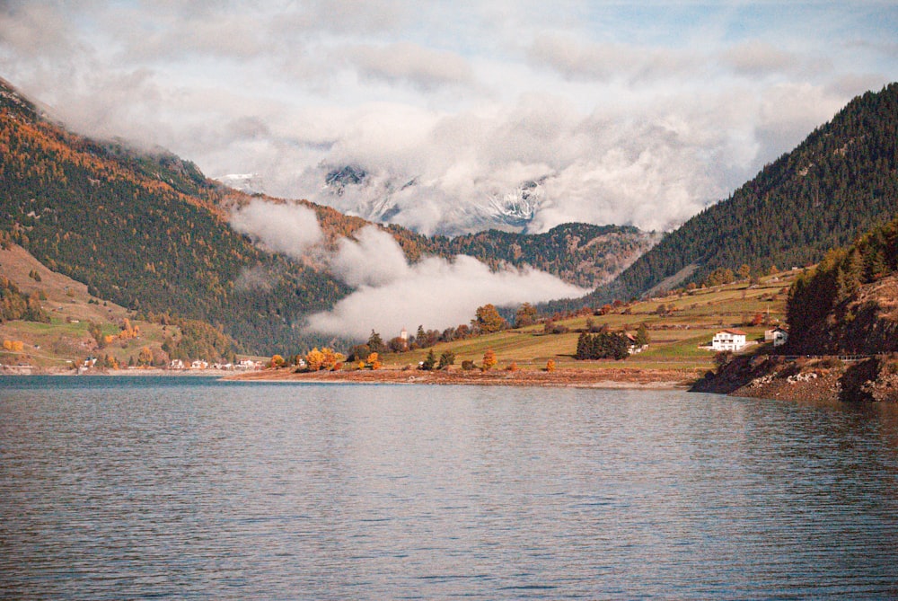 a body of water with mountains and a house on the side
