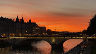 Sunset over Prague Old Town with Charles Bridge and historic rooftops.