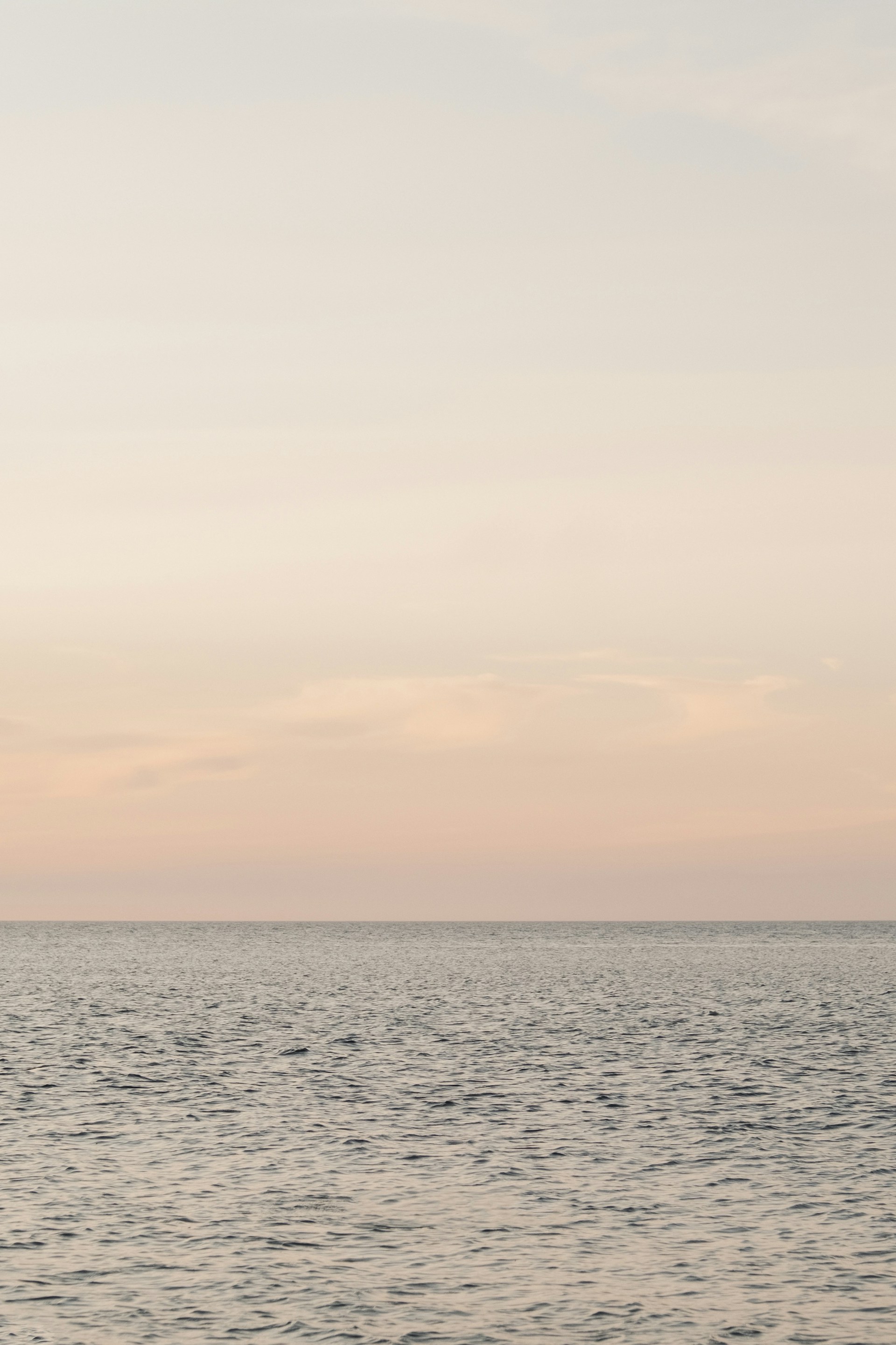 a body of water with a cloudy sky above it
