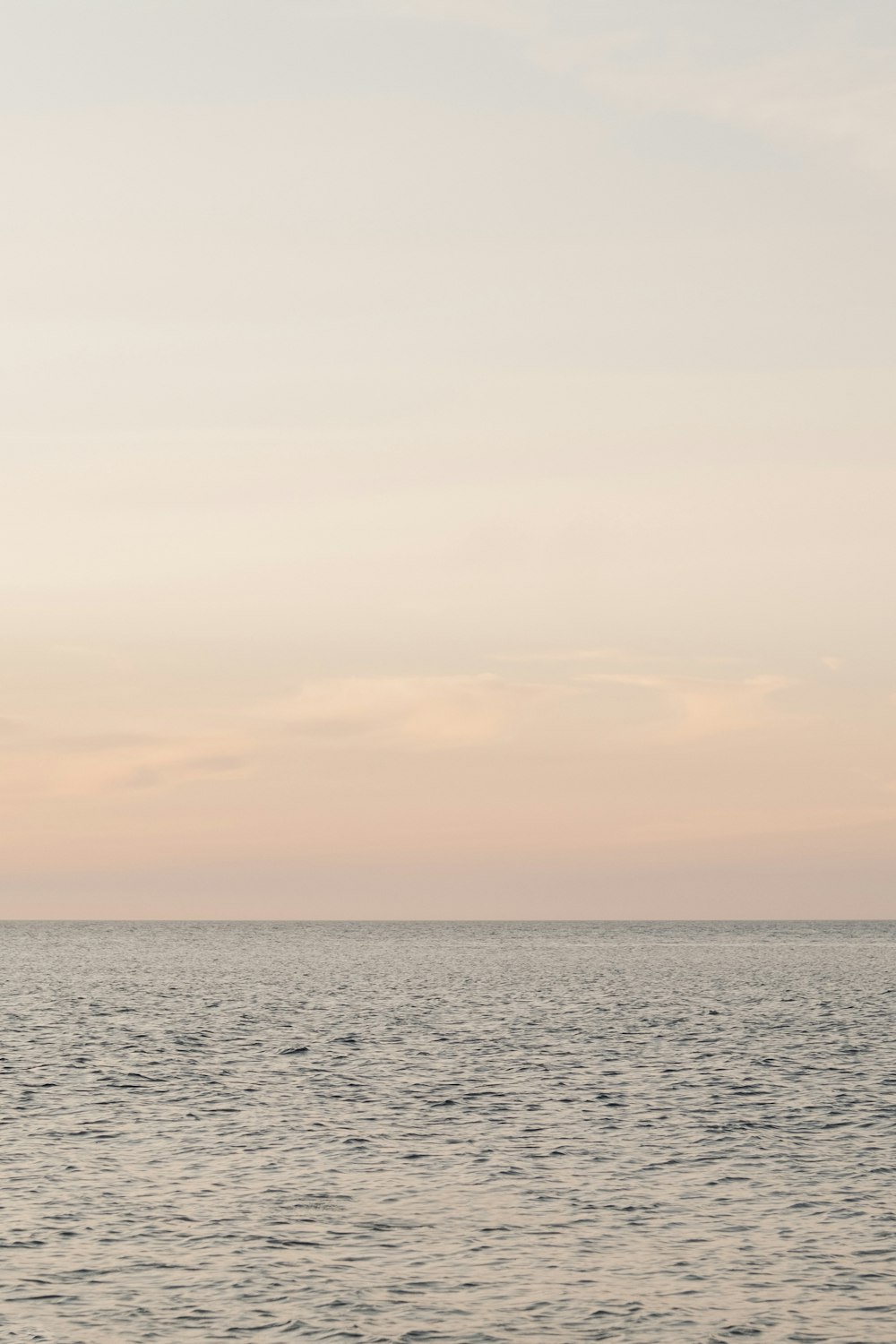 a body of water with a cloudy sky above it