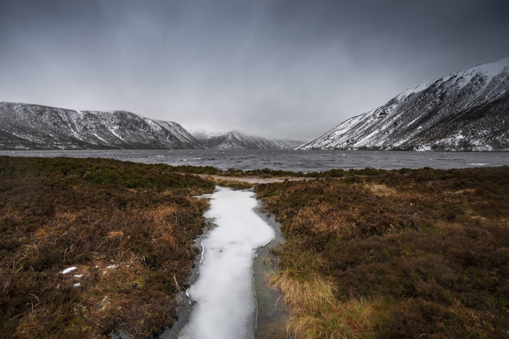 a stream running through a snowy landscape