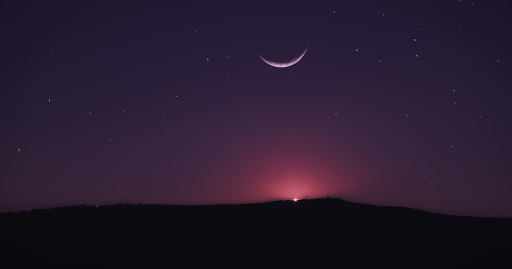 Un cielo notturno con una falce di luna
