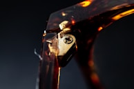Close-up detail of a gold-accented hinge on an exquisite eyeglass frame.