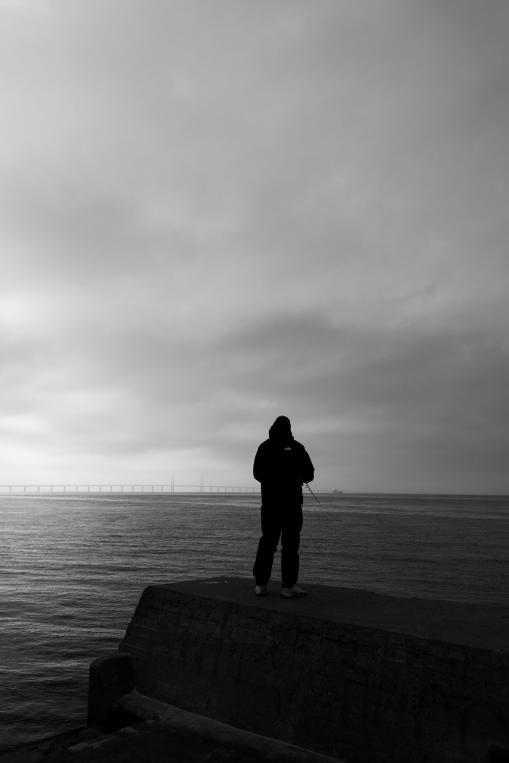 Eine Person, die auf einem Dock steht und auf das Wasser schaut