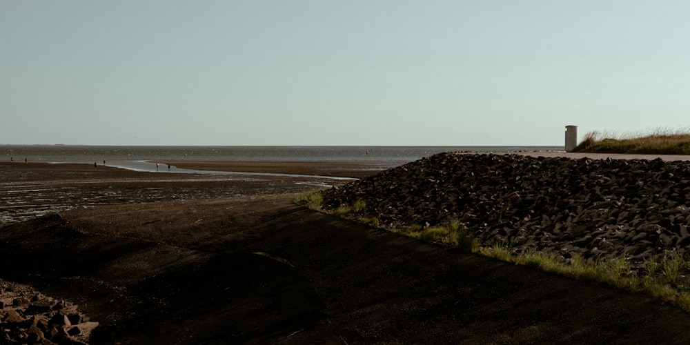 une plage avec des rochers et un plan d’eau