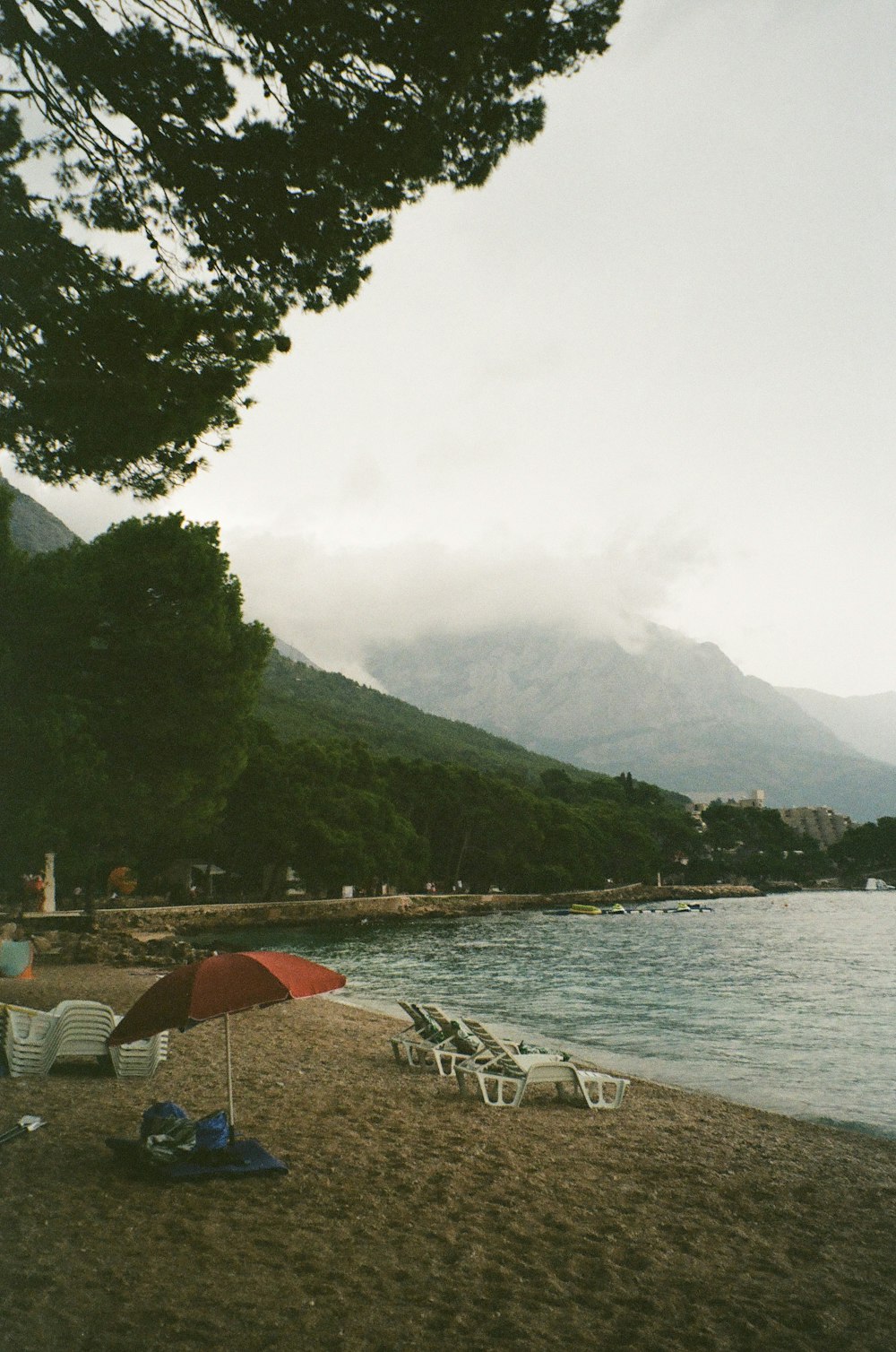 a group of chairs and umbrellas by a body of water