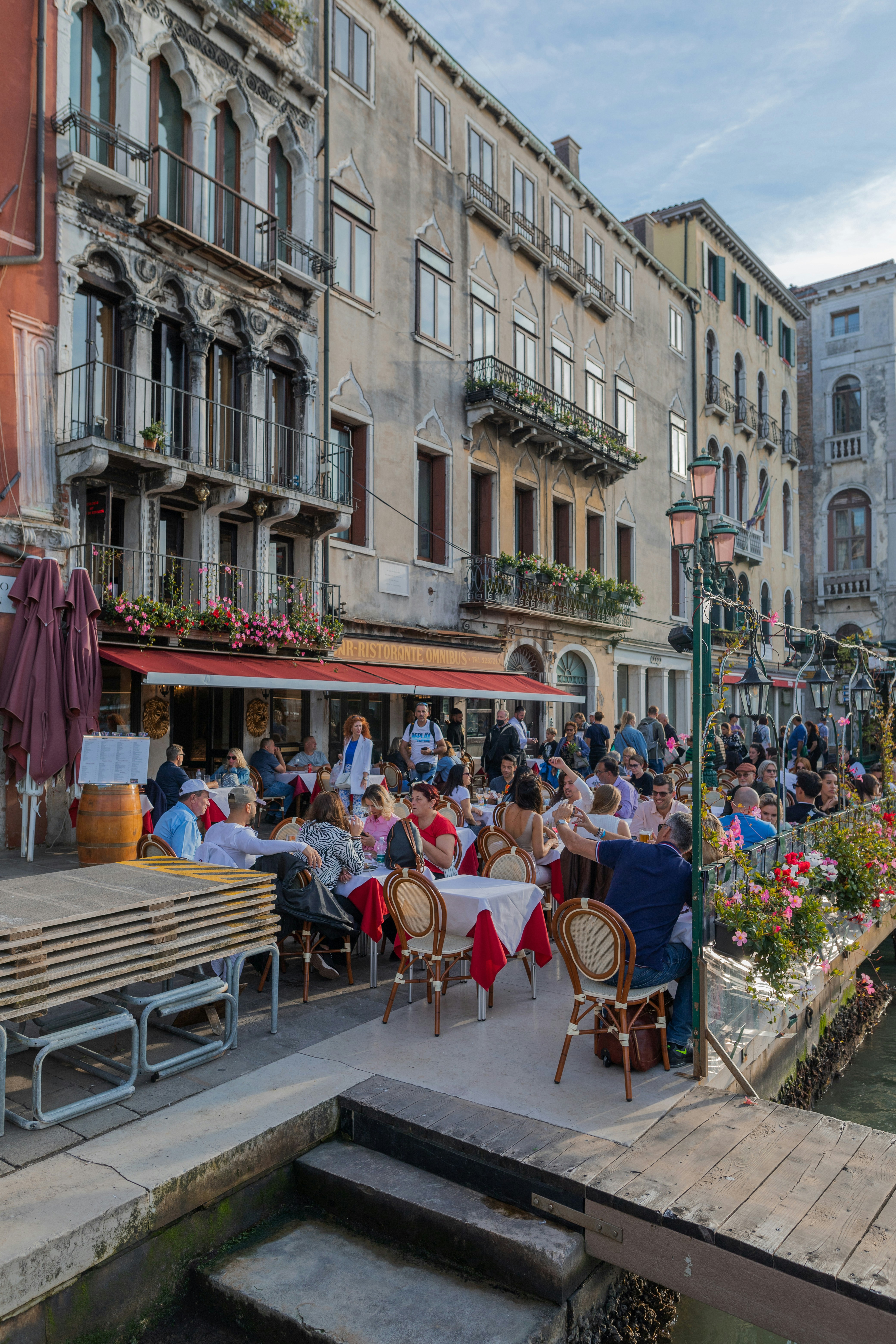a group of people sitting at tables in a street