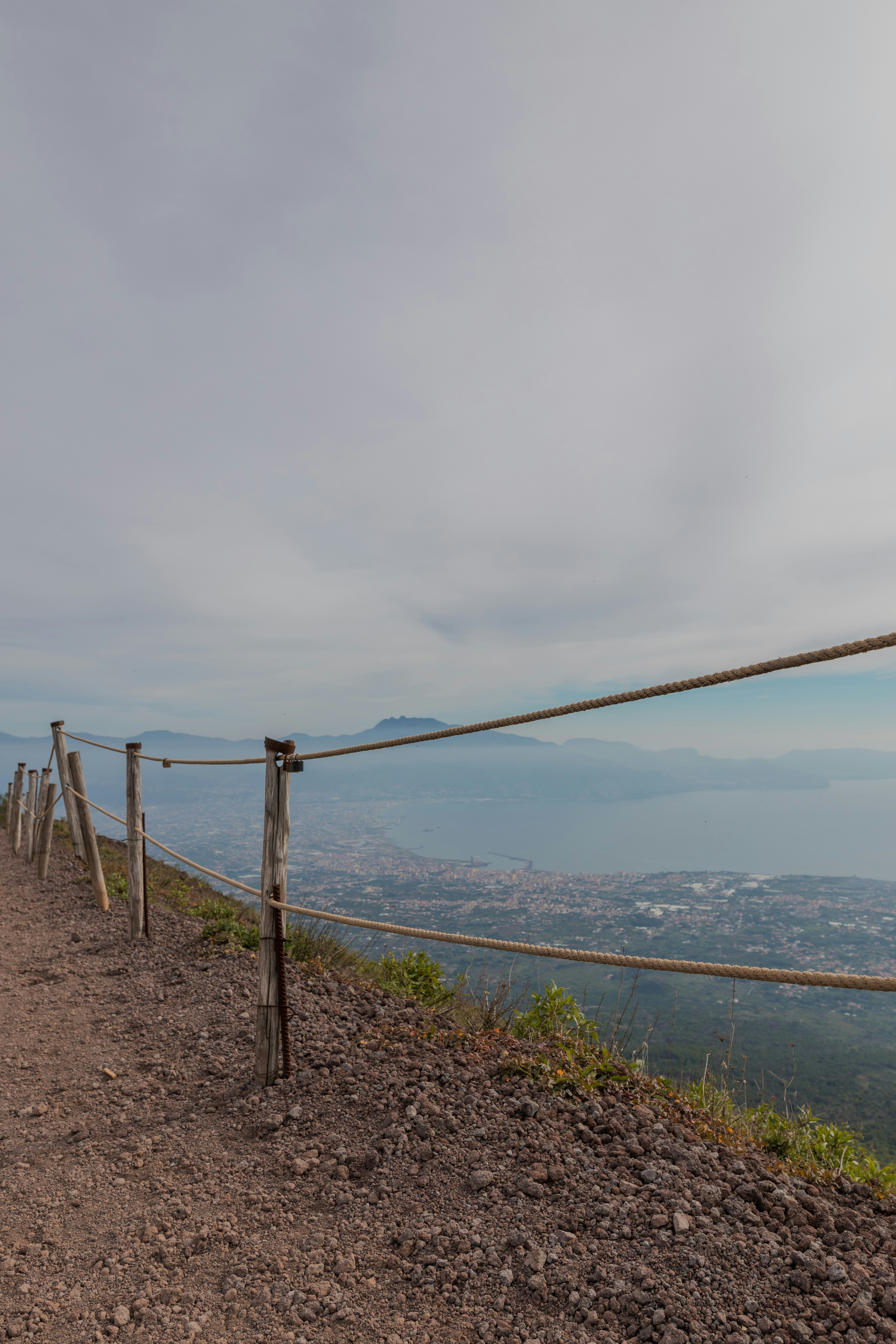 A fence on a hill overlooking a body of water photo – Free Italy Image ...