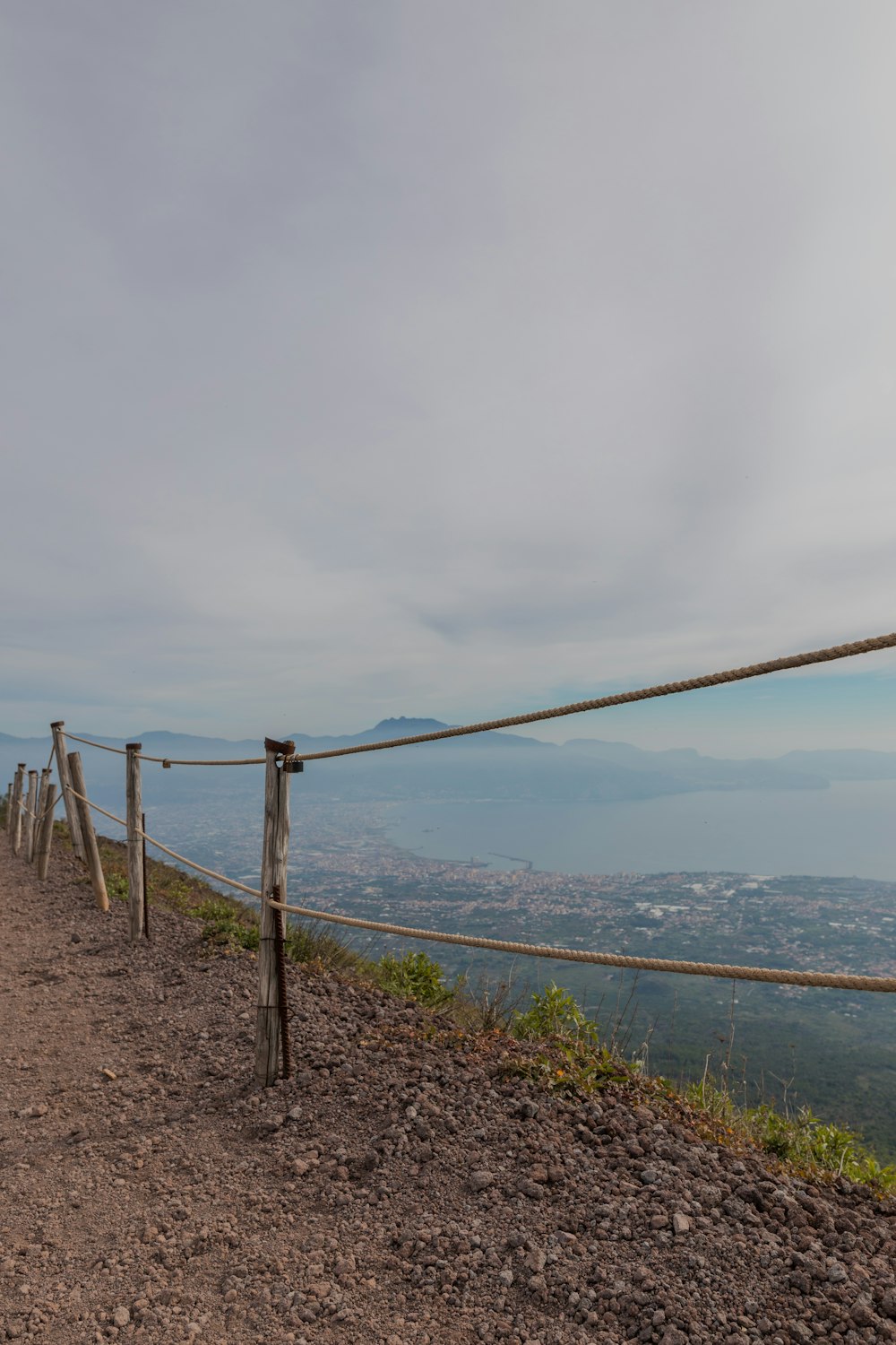 a fence on a hill overlooking a body of water