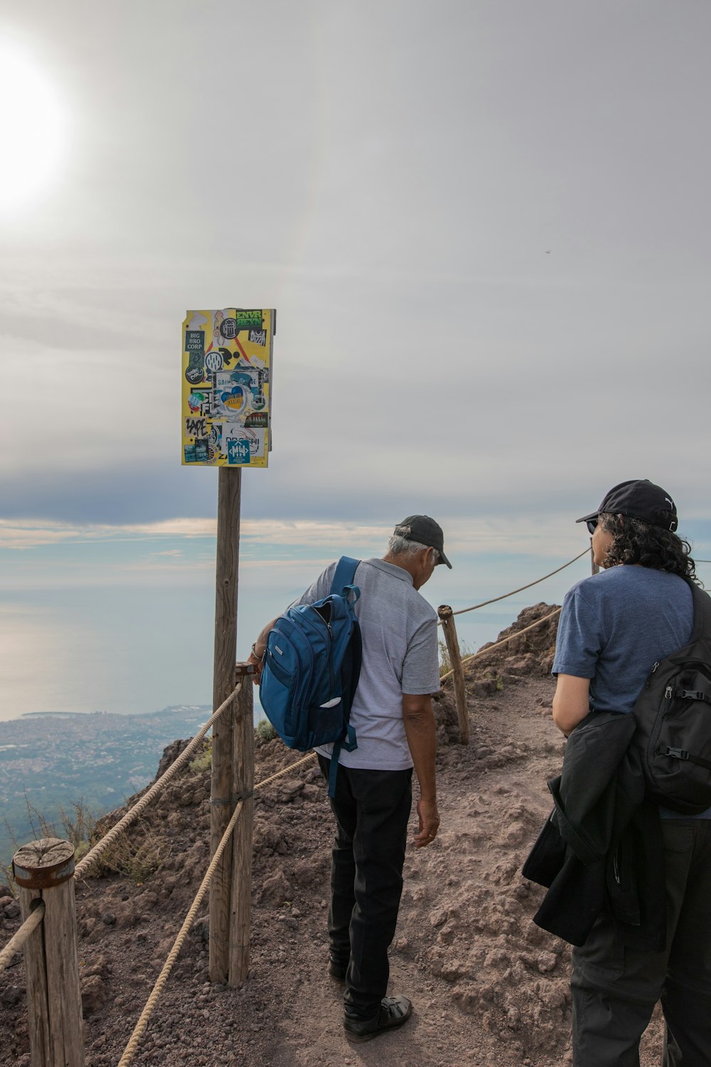 a group of people looking at a sign on a mountain