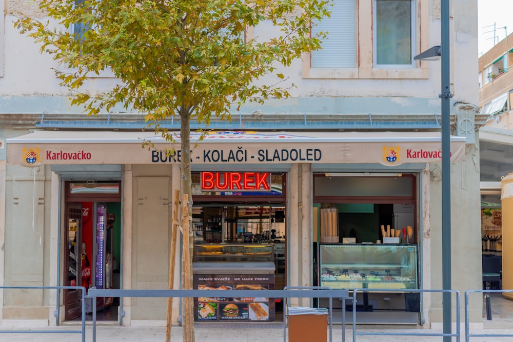 a store front with a tree in the front