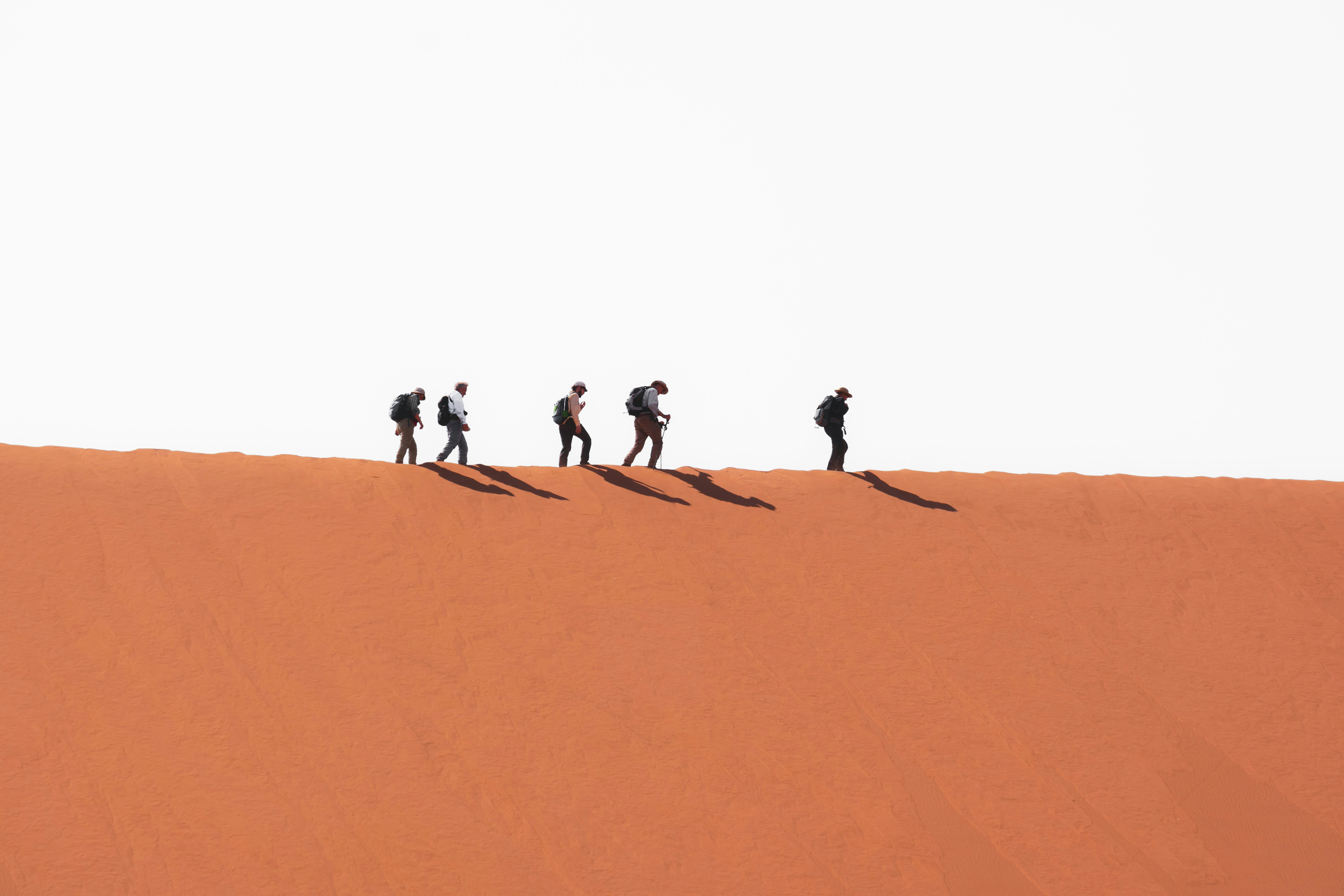 great photo recipe,how to photograph people walking on a dune; a group of people walking on sand