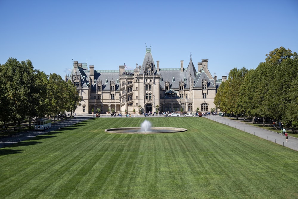a large building with a fountain in front of it with Biltmore Estate in the background