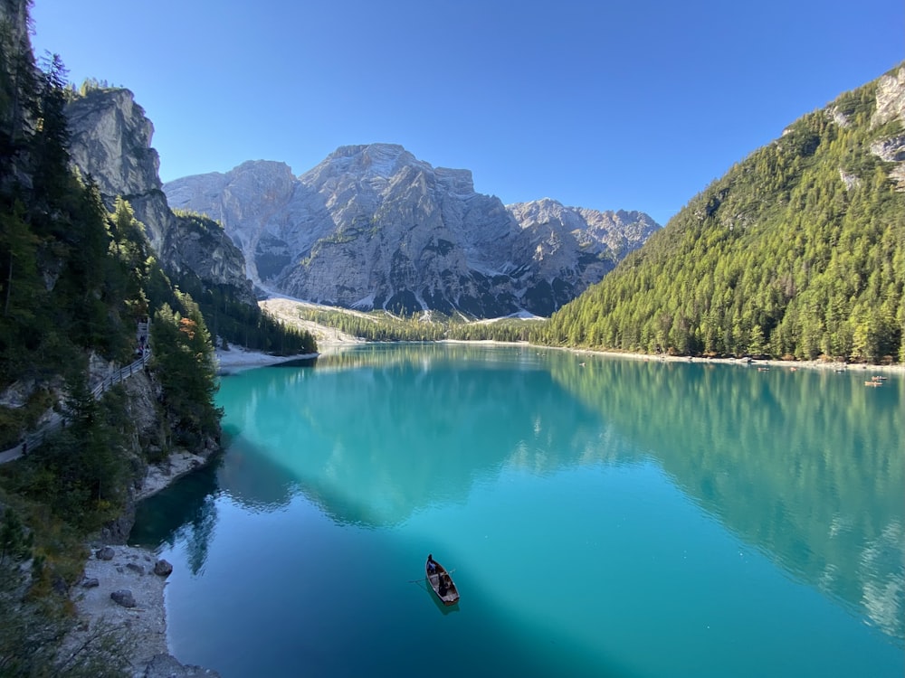 a person swimming in a lake surrounded by mountains