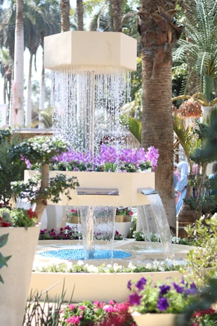 A serene corner featuring a decorative water fountain and lush greenery.