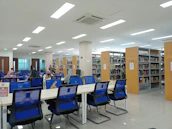 Students using tablets and books in a vibrant school library decorated with blue and gold.