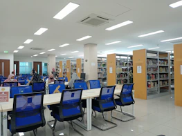 Students using tablets and books in a vibrant school library decorated with blue and gold.