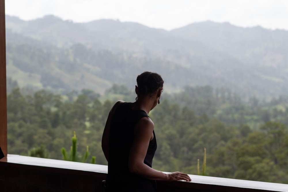 a person standing on a balcony overlooking a valley