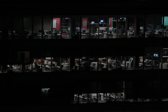 A dedicated team working late at night in a modern office with blue and black tones.