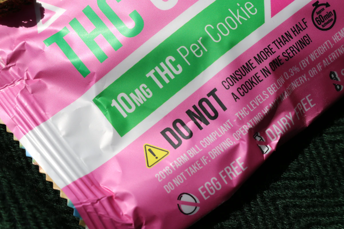 Close-up of a compliant edible label reading 10 mg THC per cookie with a do-not-exceed serving warning