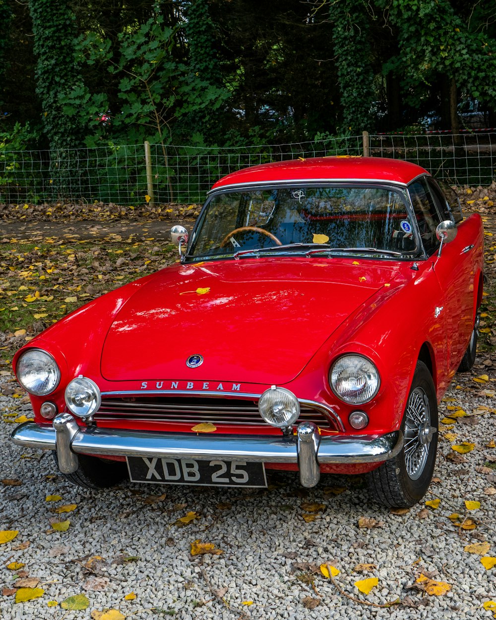 a red car parked on gravel