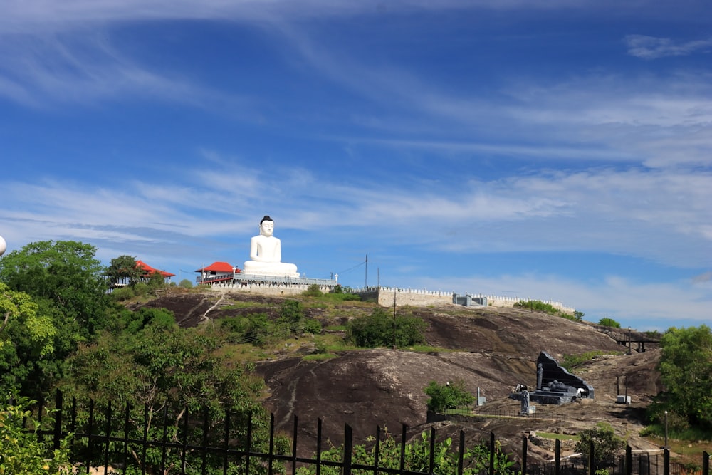 a white statue on a hill