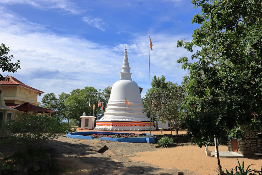 a white building with a red roof and a flag on top with Anuradhapura in the background