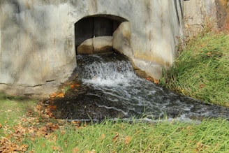 a small waterfall in a stone tunnel