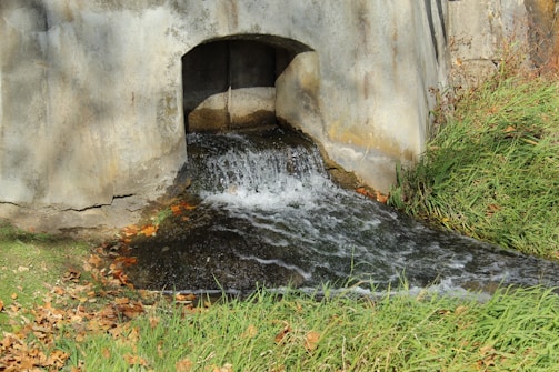 a small waterfall in a stone tunnel
