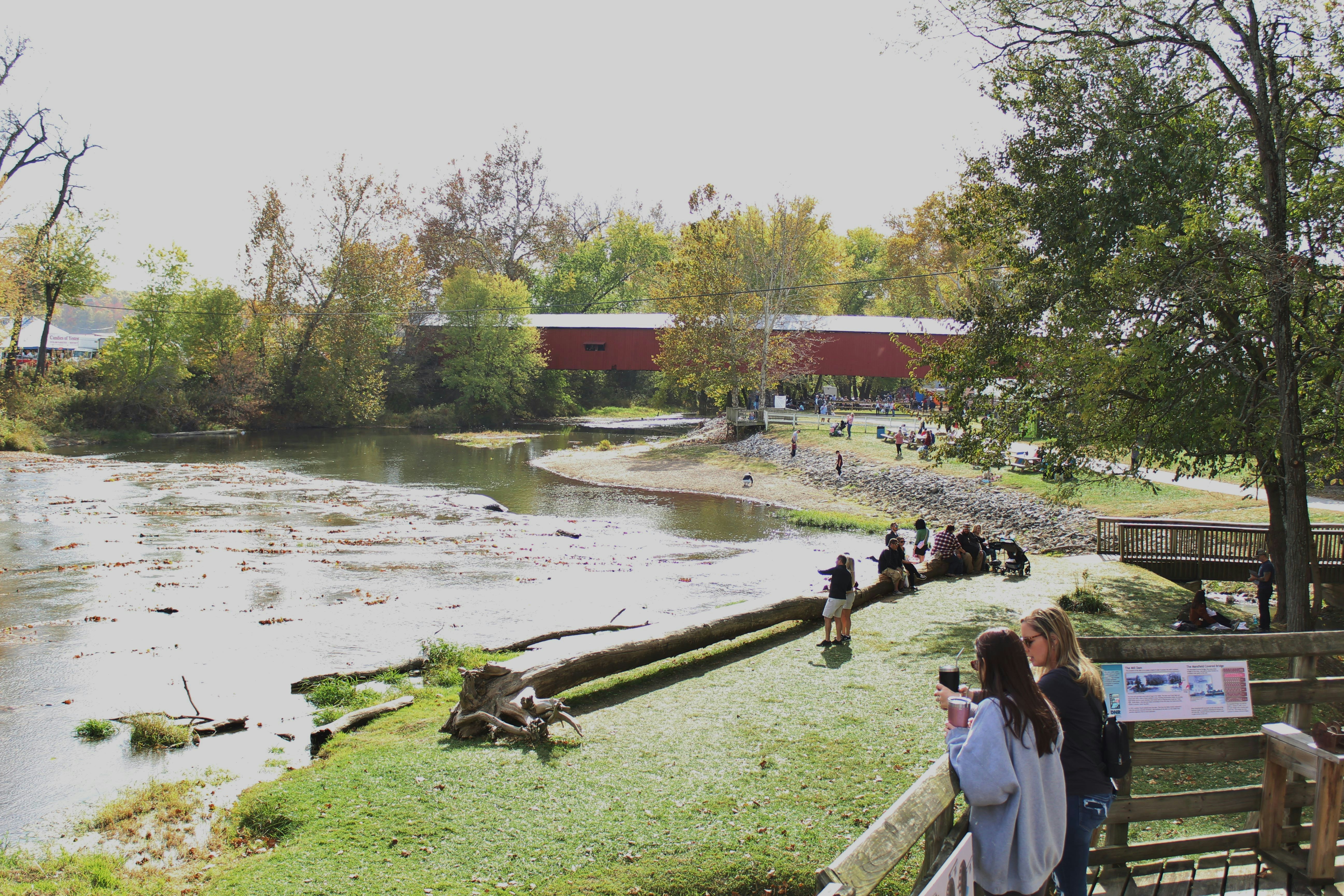 a group of people standing on a bridge over a river