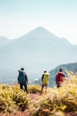A group of hikers pausing at a scenic overlook with views of the Three Sisters mountains.