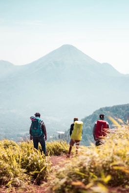 A group of hikers pausing at a scenic overlook with views of the Three Sisters mountains.