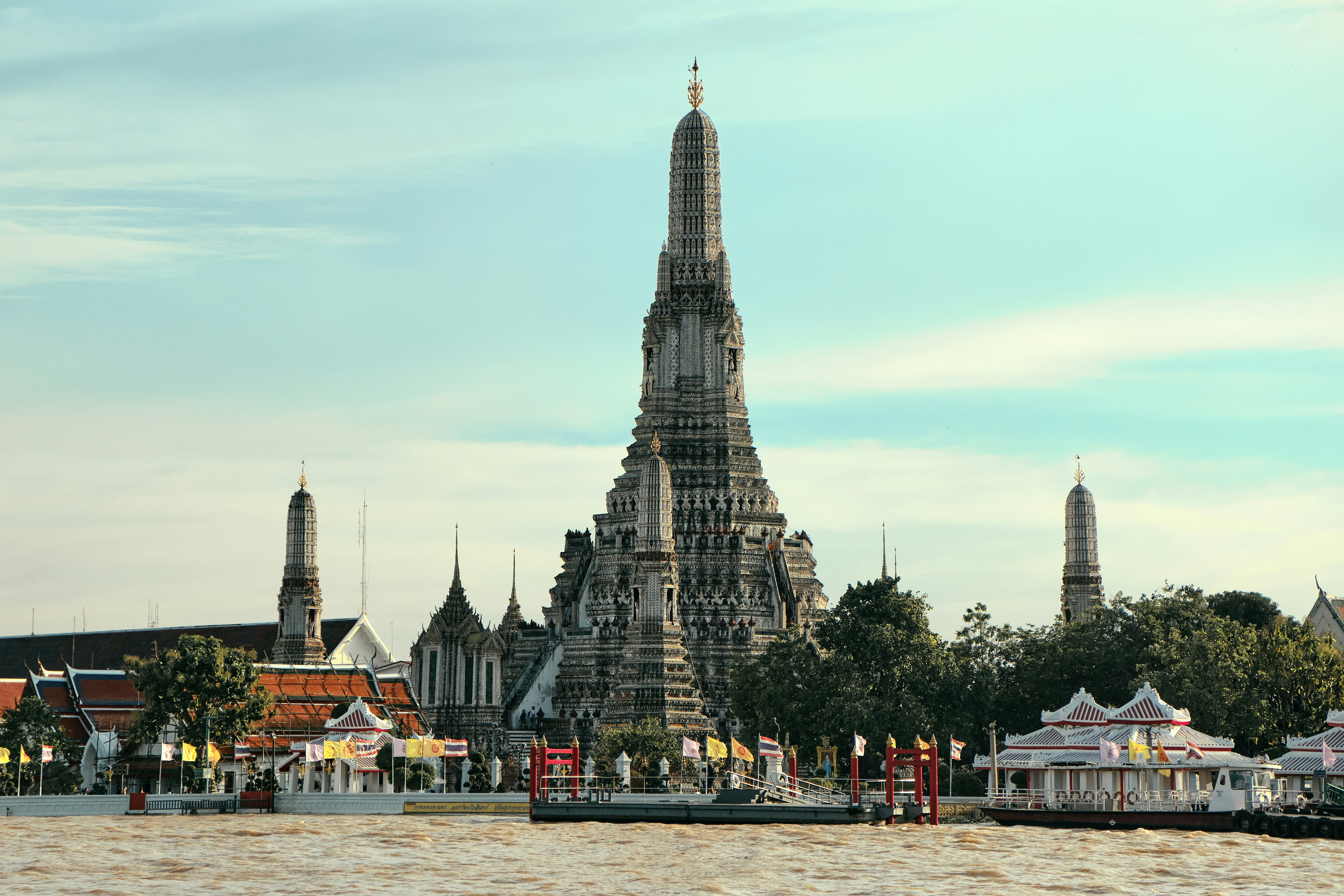 a large building with pointy towers with Wat Arun in the background