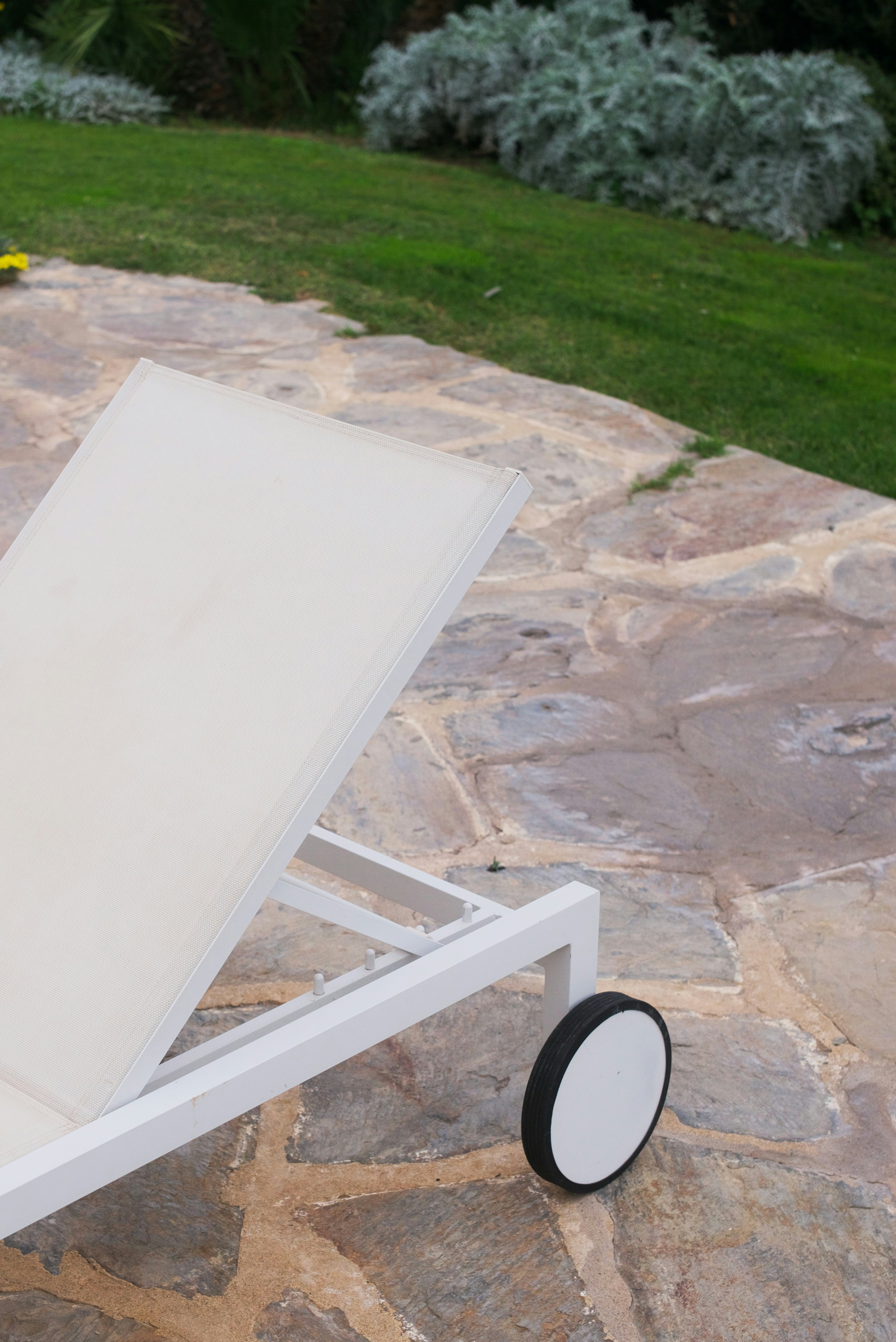 a white bench on a stone path