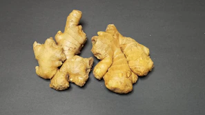 Close-up of fresh ginger root nestled among vibrant African fabrics.
