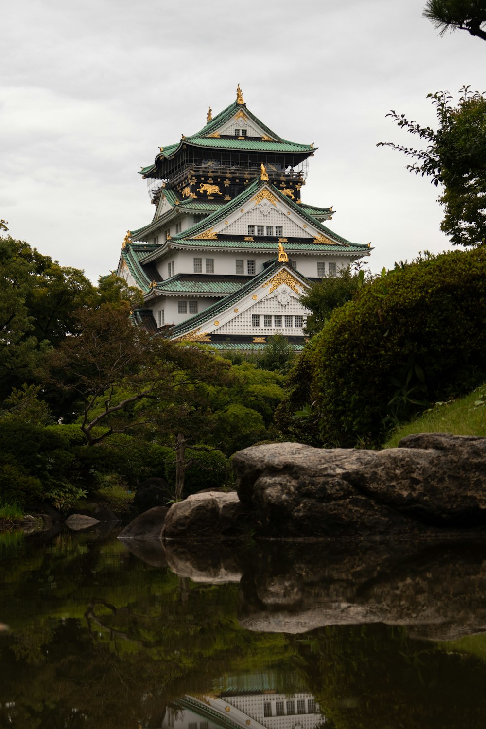 Osaka Castle with a green roof surrounded by trees and rocks