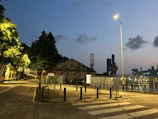 A peaceful city street at dusk, glowing softly under vintage street lamps.