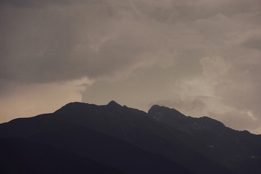 a mountain with clouds above it