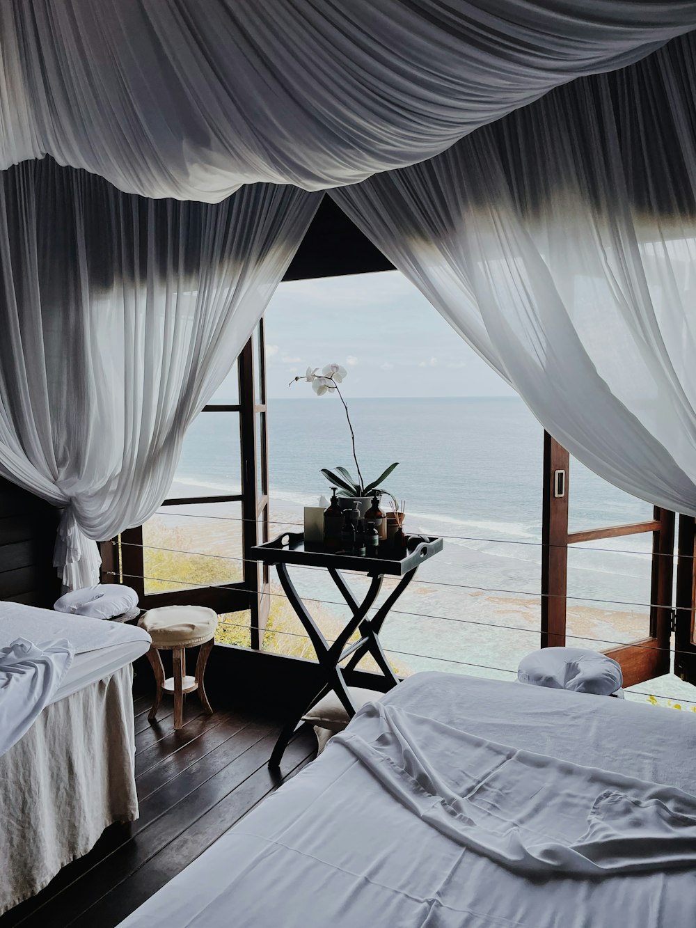 a room with a table and chairs and a view of the ocean