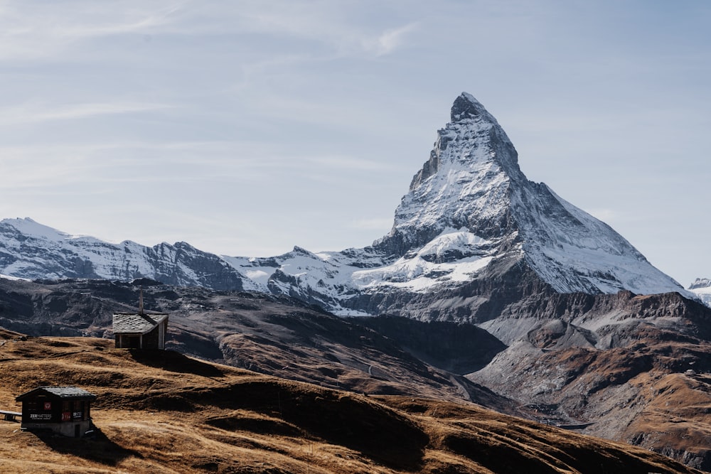 a snowy mountain with a small building with Matterhorn in the background