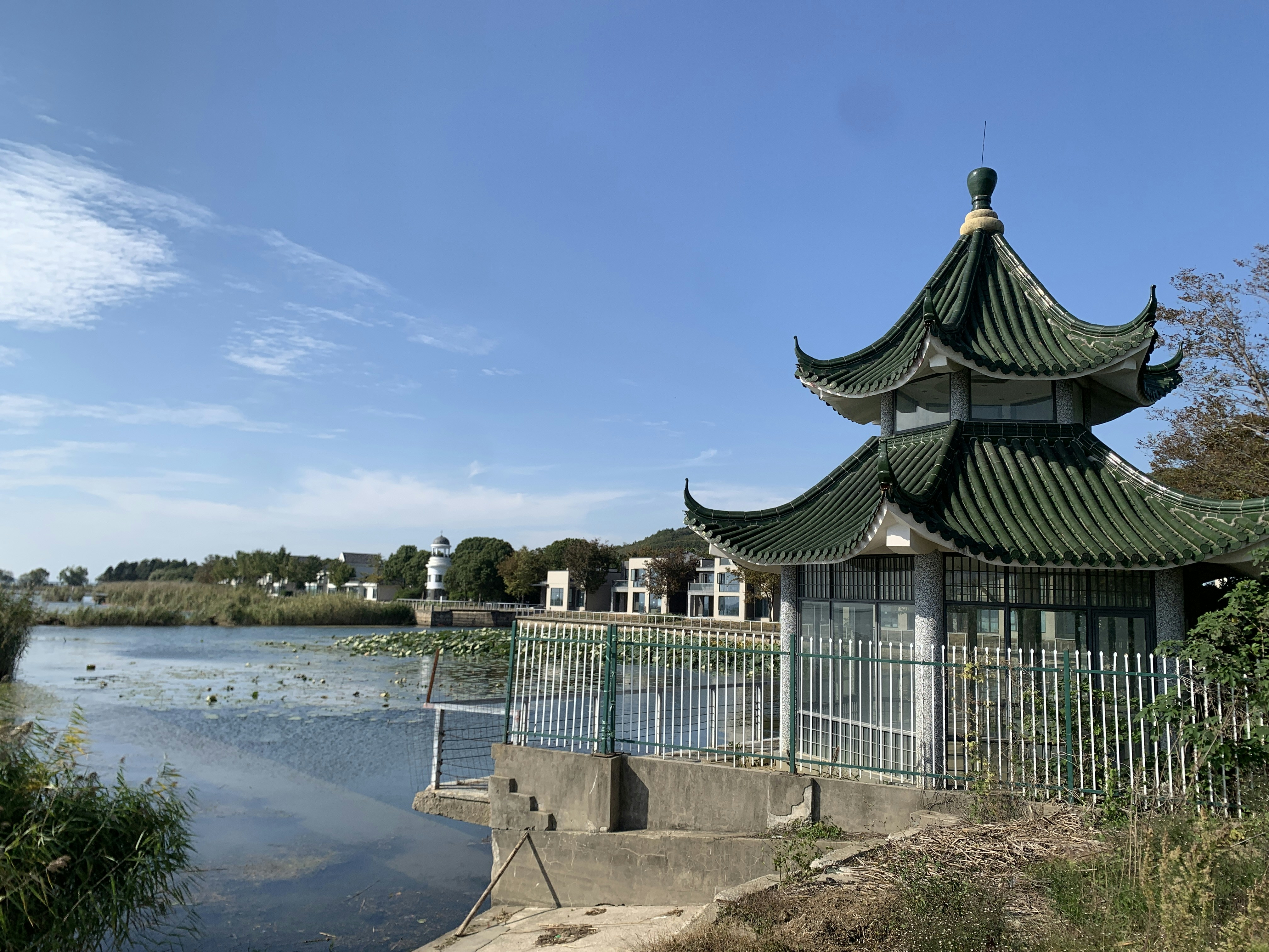 a building with a fence around it by a body of water