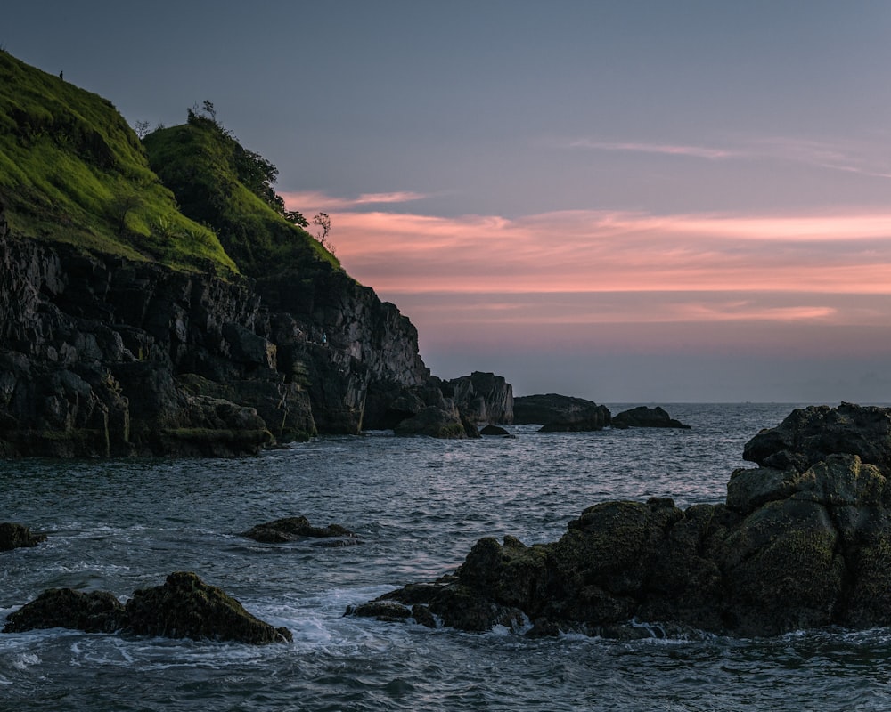 a rocky beach with a hill in the background